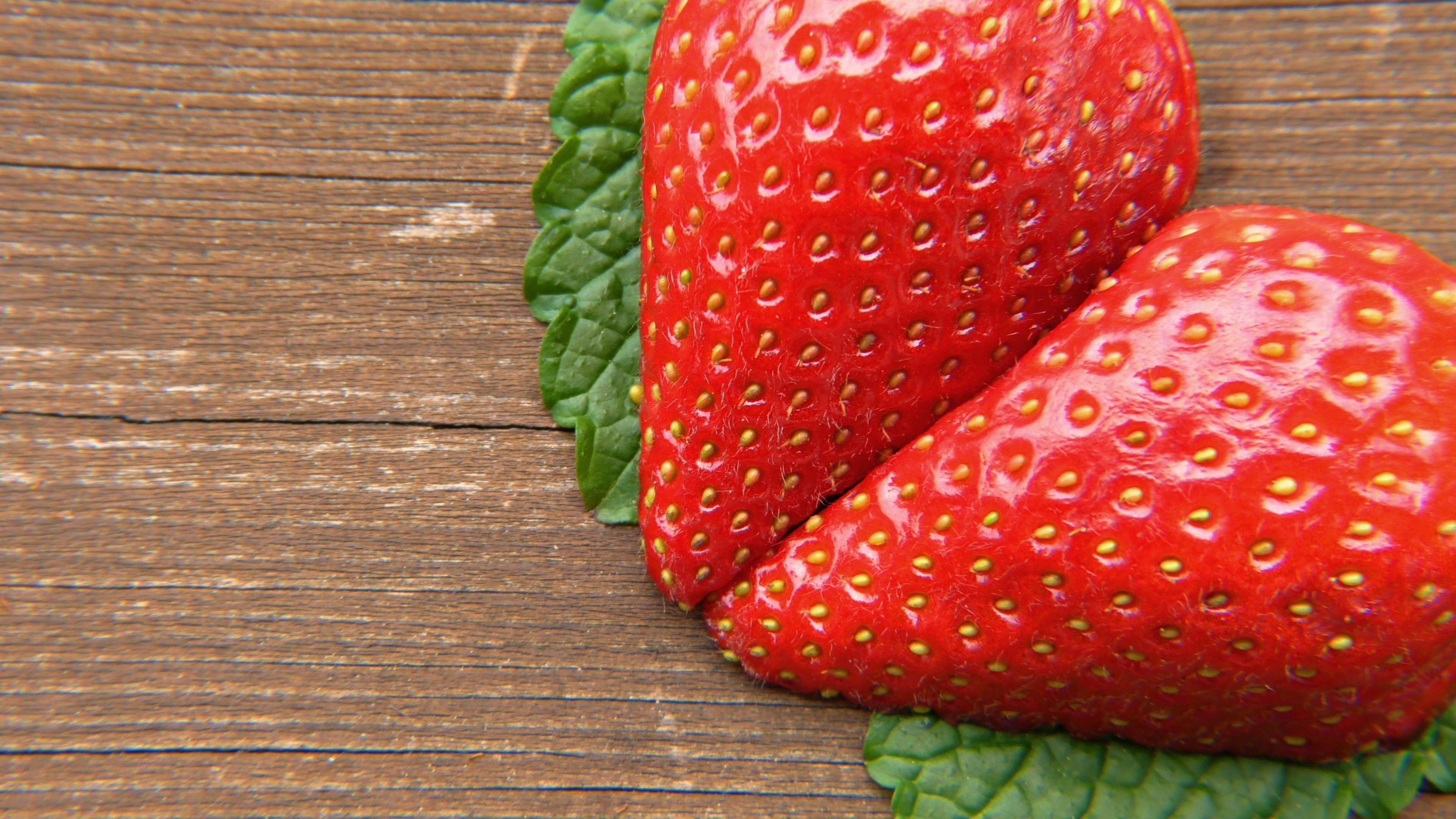 Two strawberries and mint leaves on wood HD Wallpaper