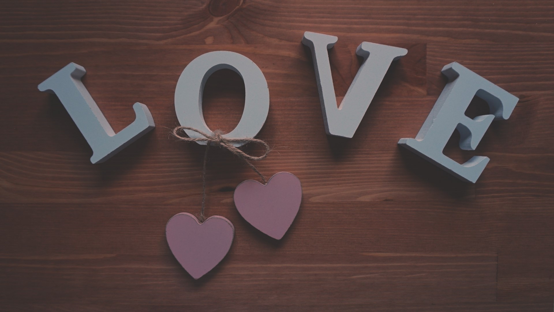 Wooden letters spelling LOVE with pink hearts HD Wallpaper