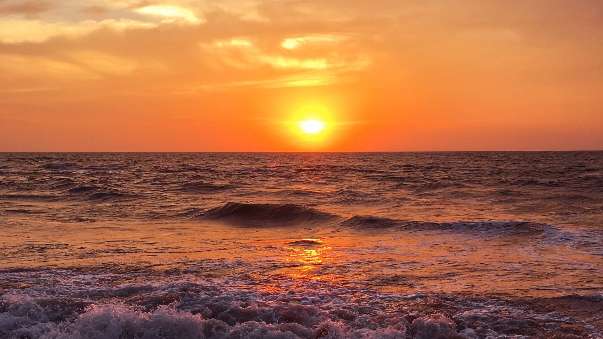 Sunset over the ocean with waves HD Wallpaper