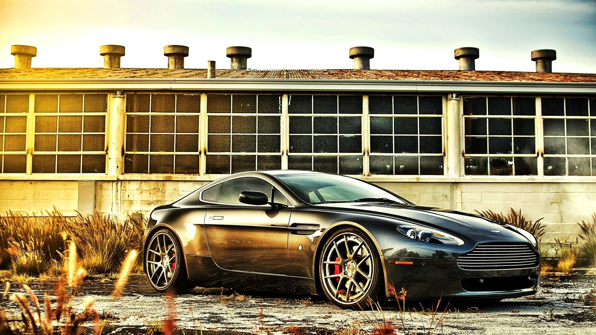 Aston Martin Vantage parked near an industrial building HD Wallpaper