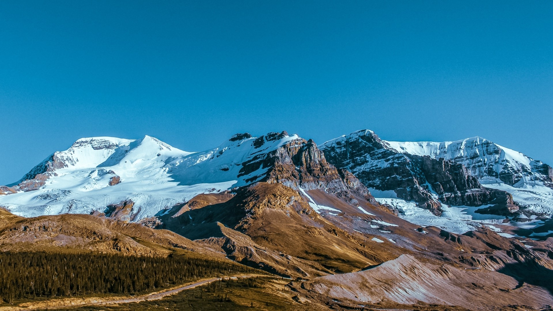 Snow-capped mountains under a clear blue sky HD Wallpaper
