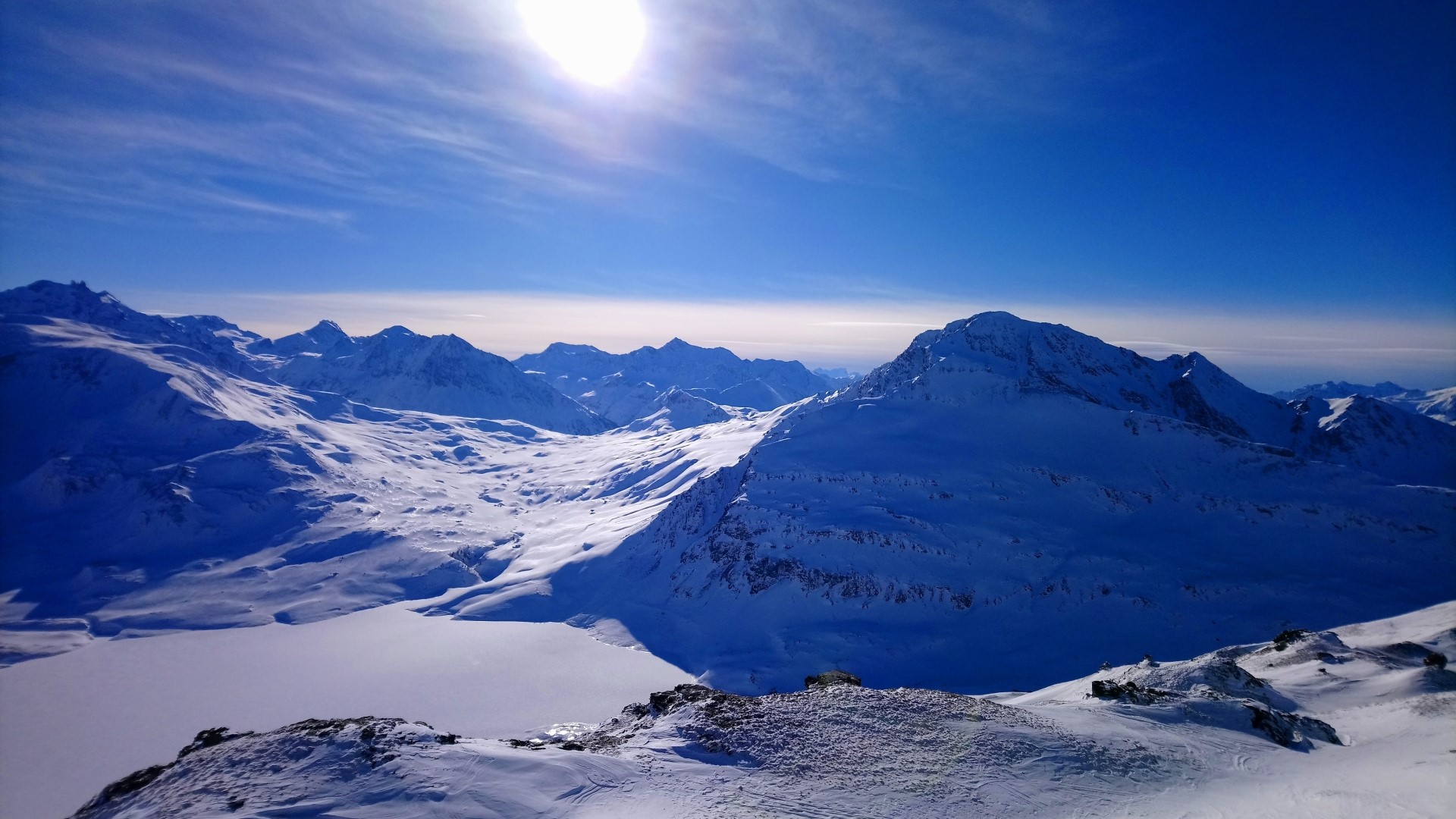 Snowy mountains under a bright sun HD Wallpaper