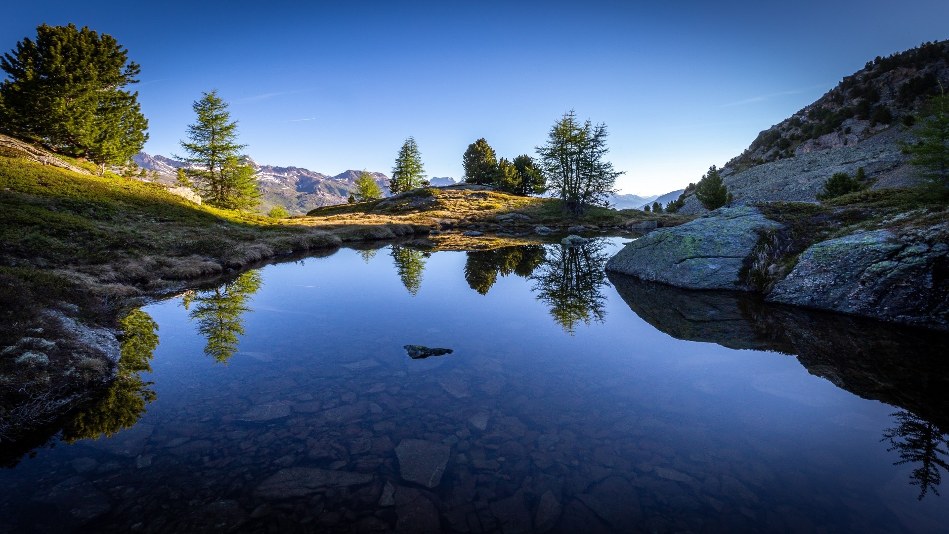 Mountain lake with reflections of trees and sky HD Wallpaper