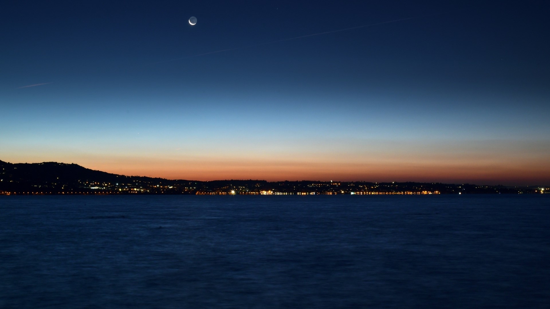 Night city lights over water with moon HD Wallpaper