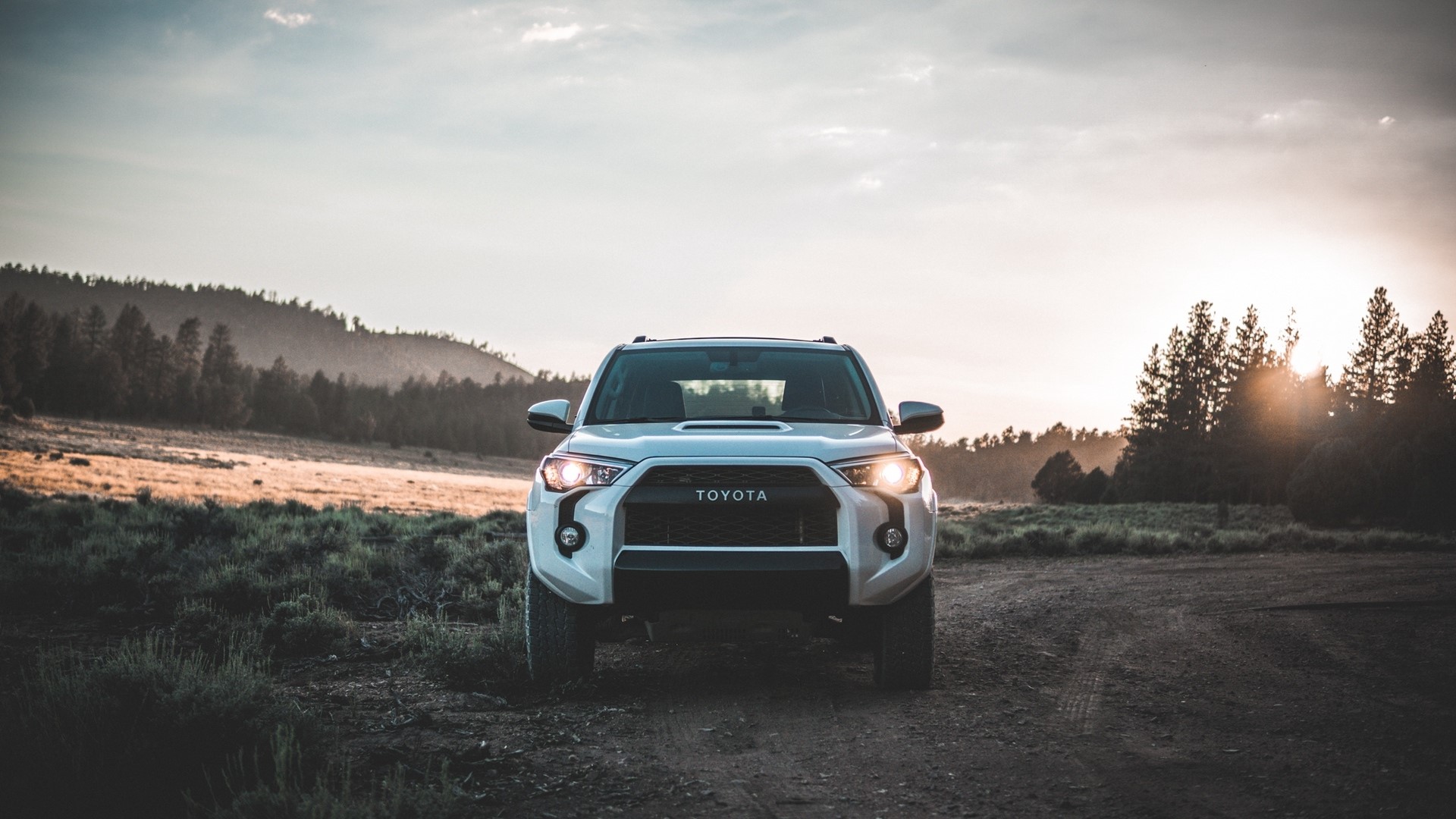 White Toyota 4Runner on a dirt road at sunset HD Wallpaper
