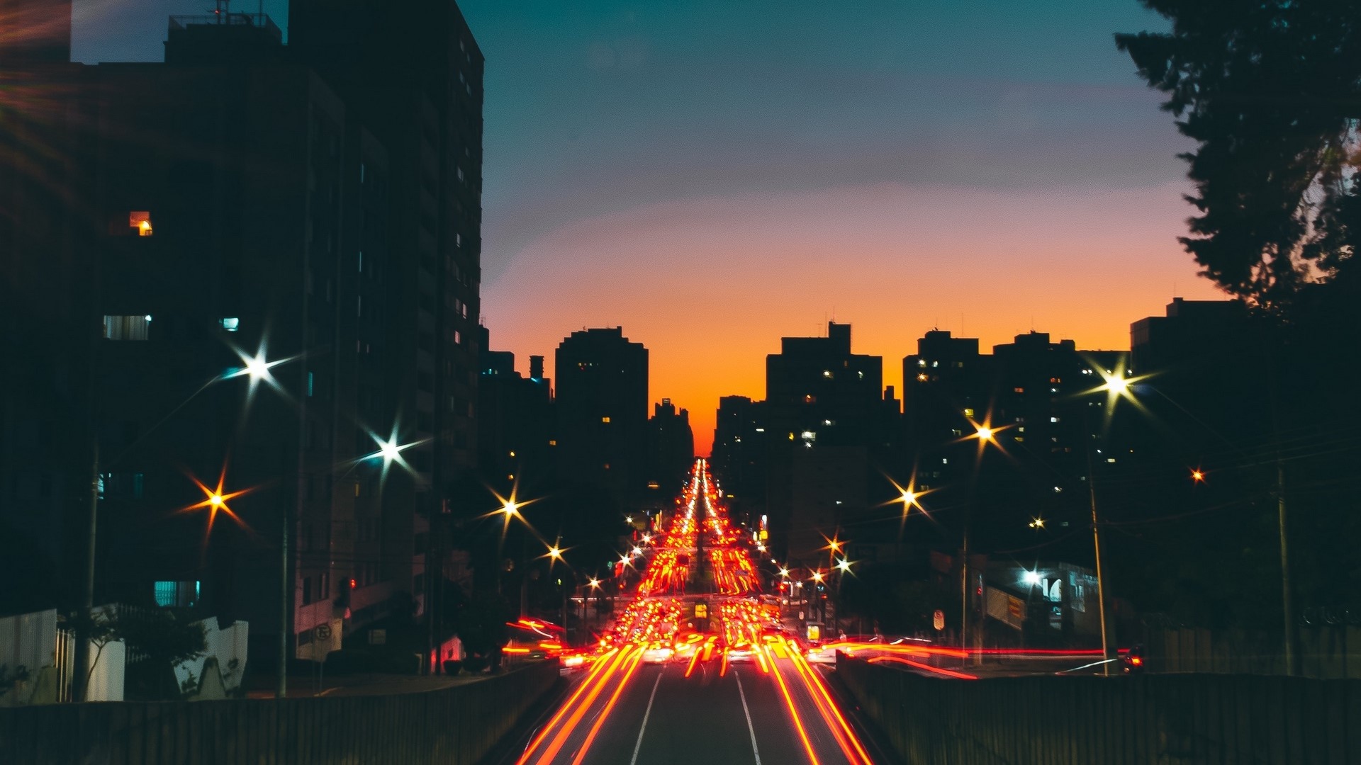 City street at dusk with light trails HD Wallpaper