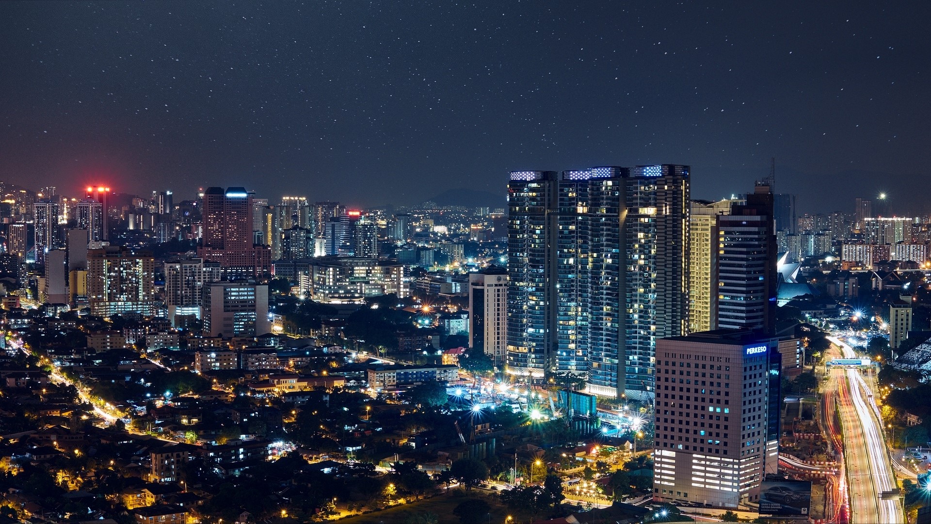 Night cityscape with illuminated skyscrapers and starry sky HD Wallpaper
