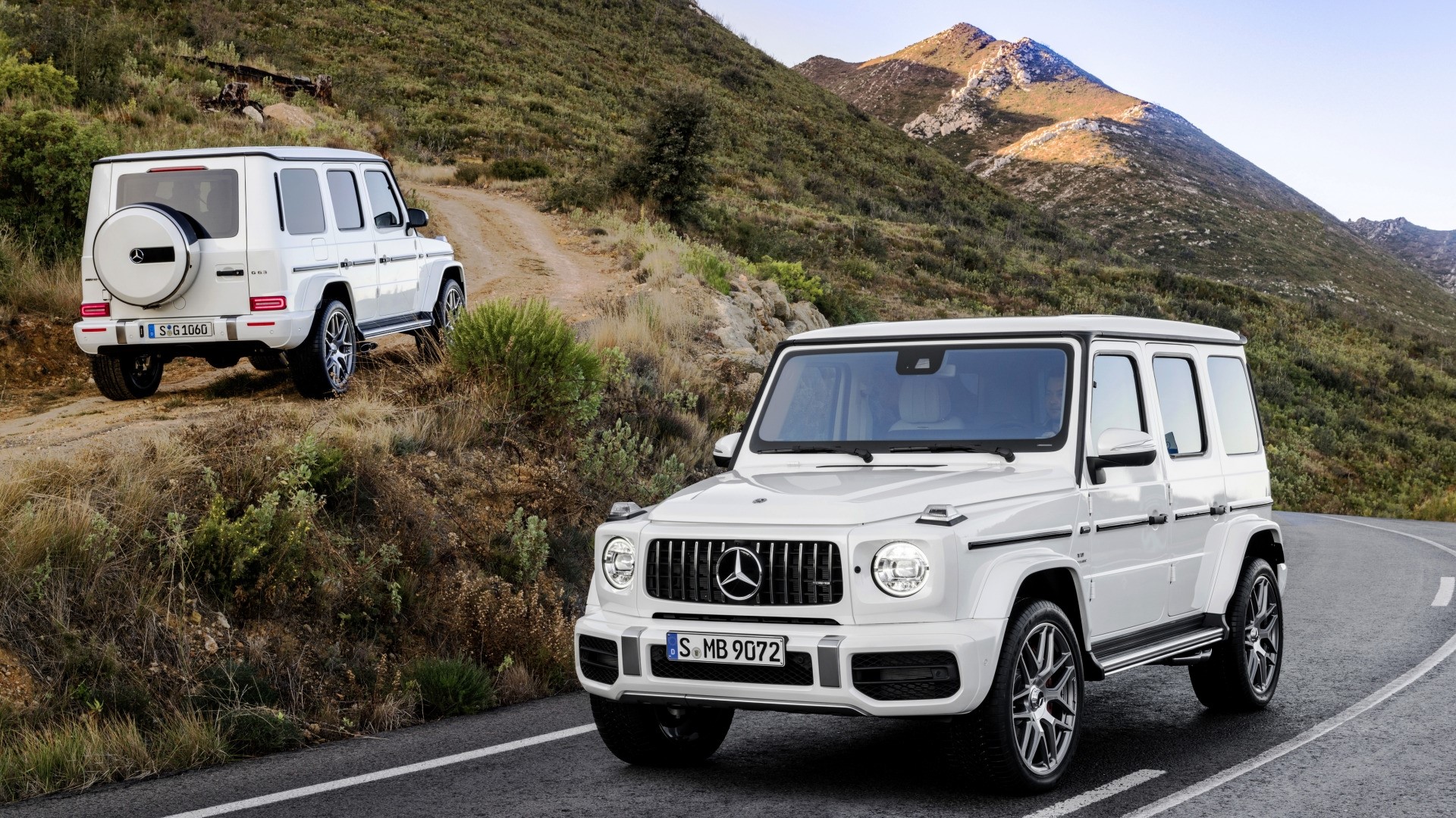 Two white Mercedes-Benz G-Wagon SUVs on a mountain road HD Wallpaper
