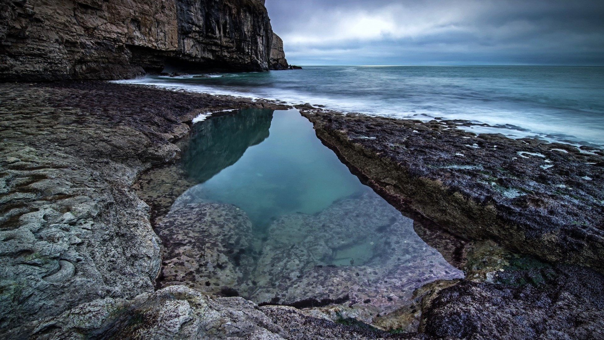 Sea cliffs and tide pool reflection HD Wallpaper