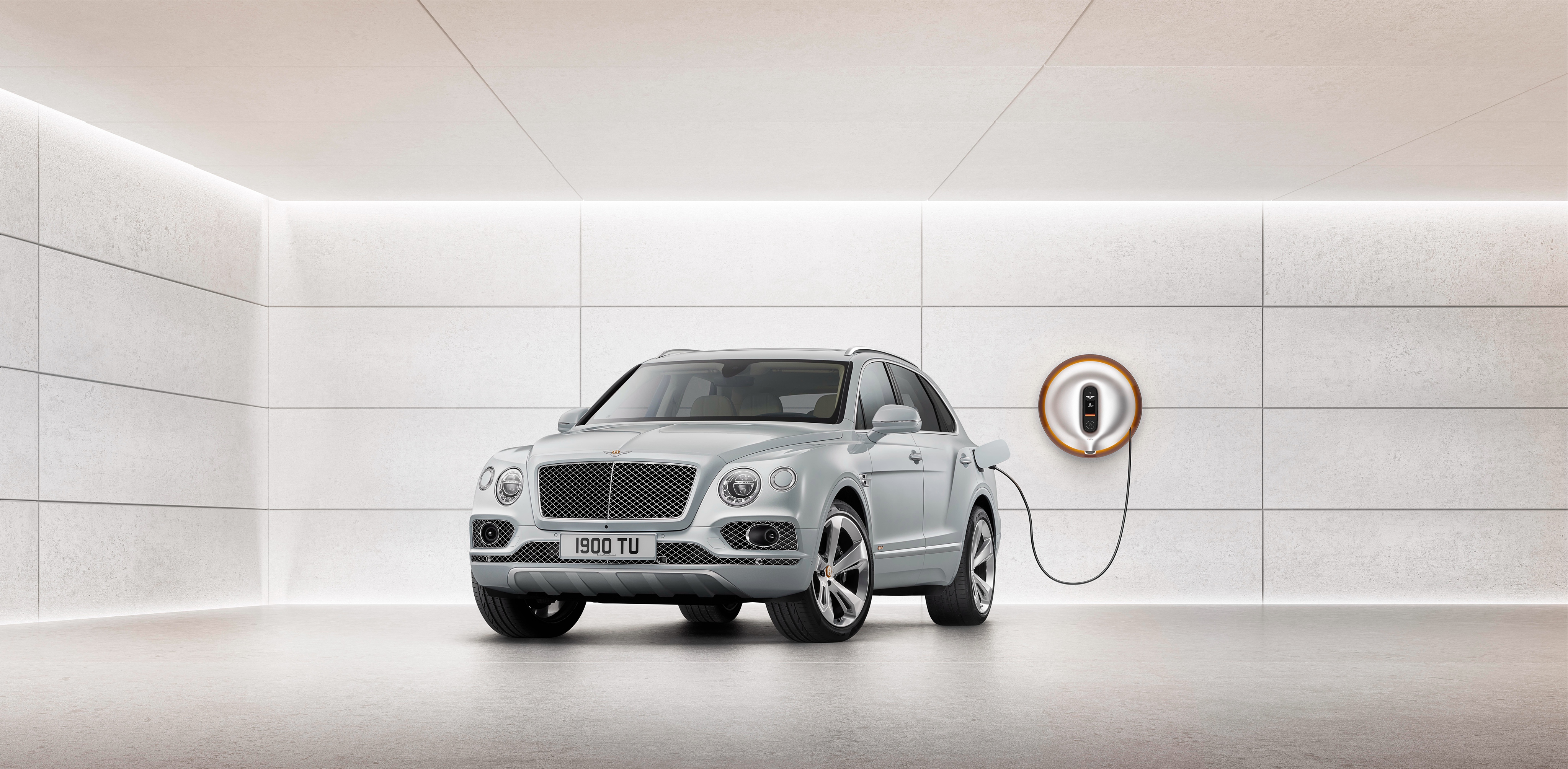 Bentley Bentayga Hybrid charging in a modern garage HD Wallpaper