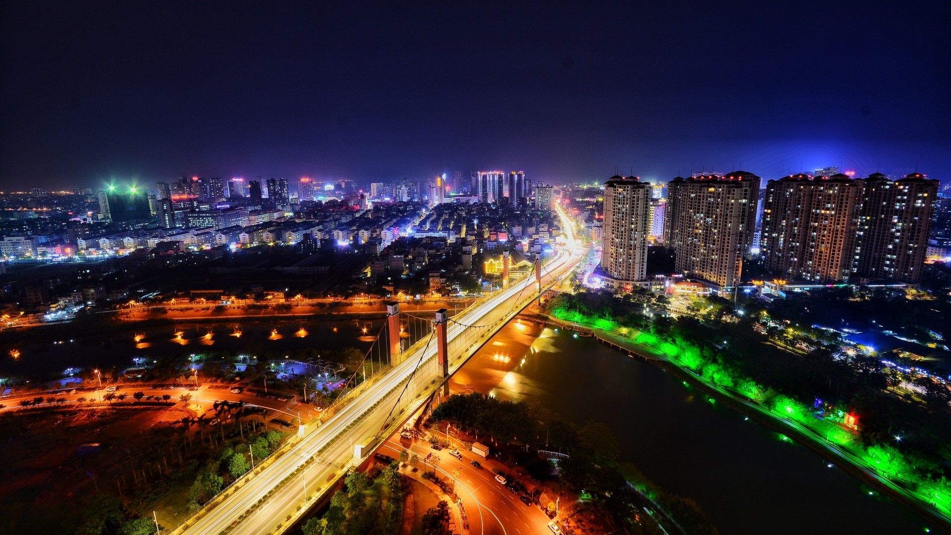 Night city skyline with illuminated bridge and buildings HD Wallpaper