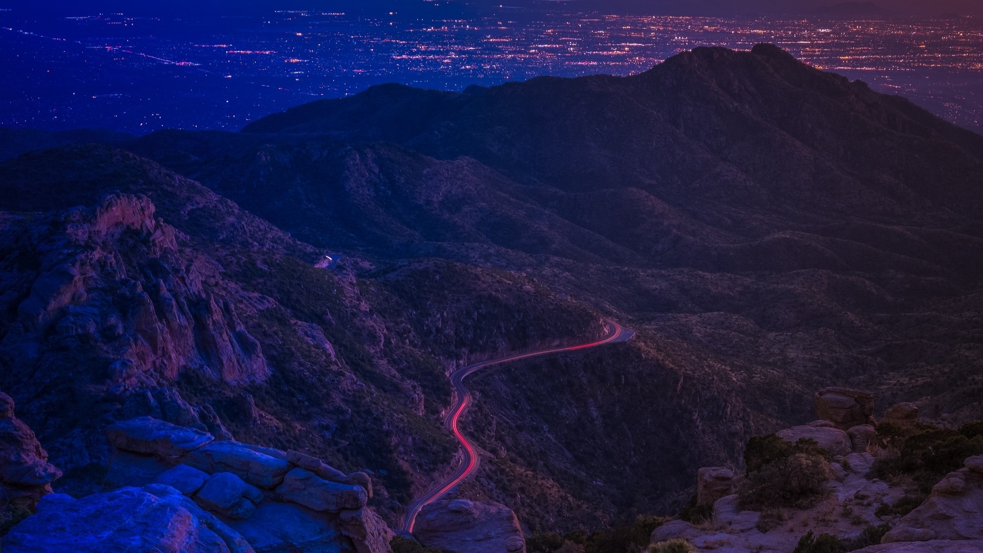 Mountain road with city lights at night HD Wallpaper
