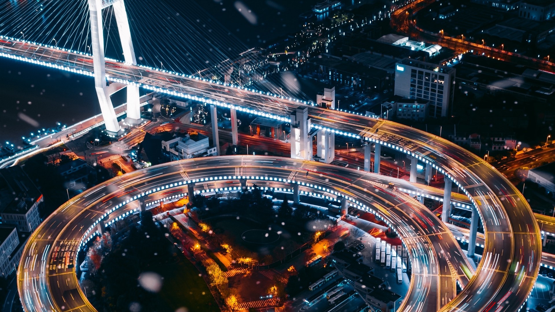 Nighttime aerial view of a busy highway interchange HD Wallpaper