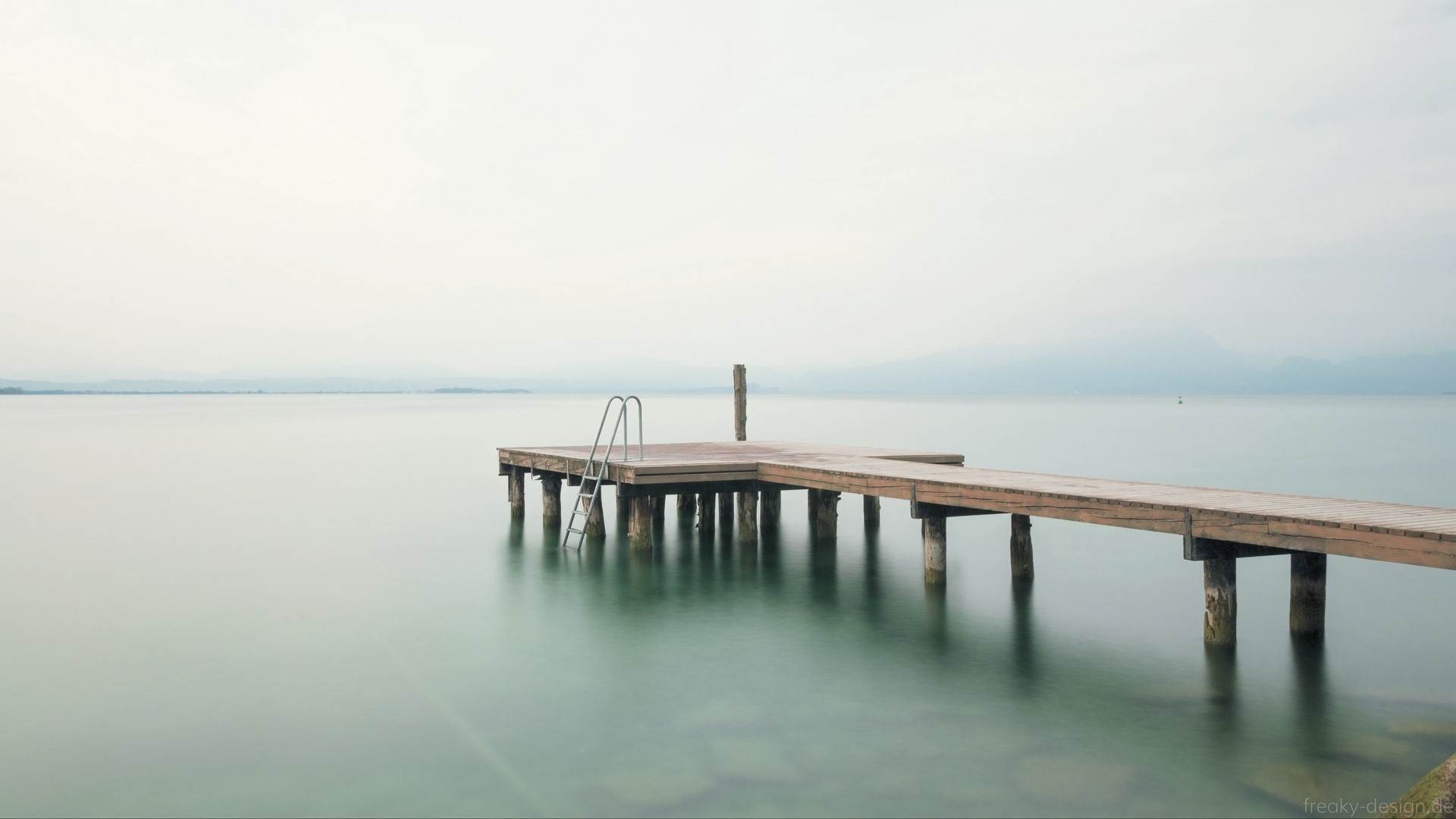 Wooden pier with ladder on a calm lake HD Wallpaper
