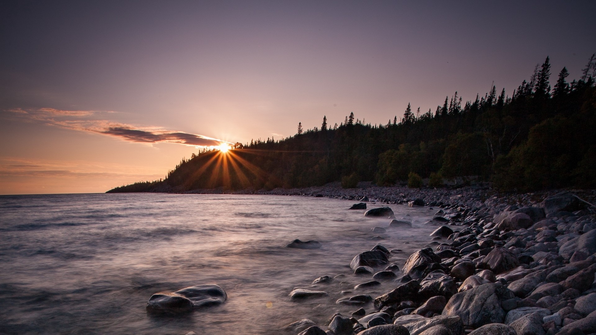 Sunset over a rocky shore with trees HD Wallpaper