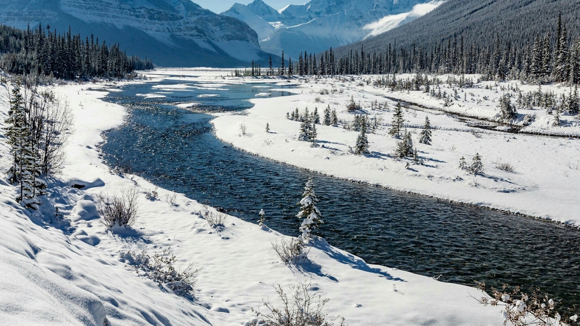 Winter river flowing through snow-covered forest and mountains HD Wallpaper