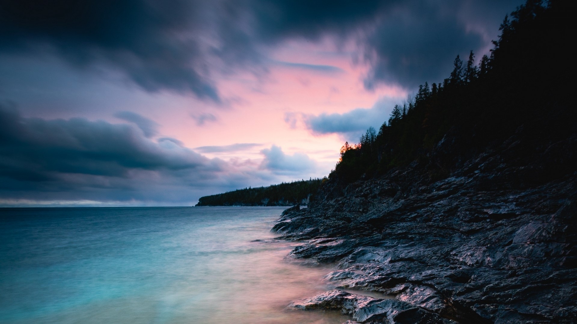 Rocky Coastline Under Dramatic Sunset Sky HD Wallpaper
