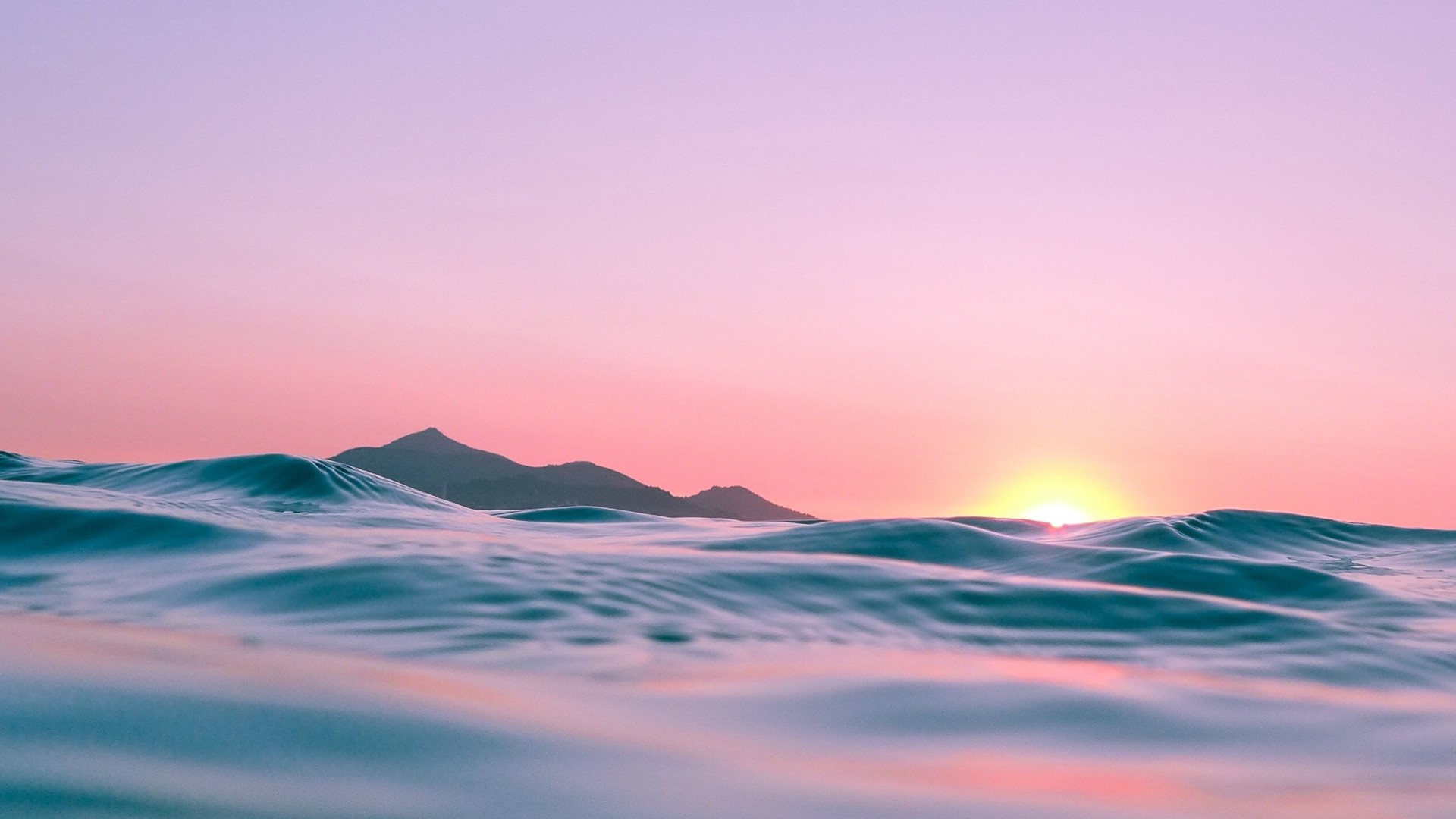 Ocean waves at sunset with mountains HD Wallpaper