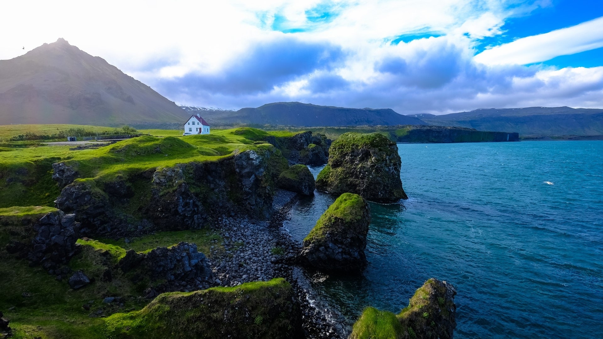 White house on a cliff overlooking the ocean HD Wallpaper