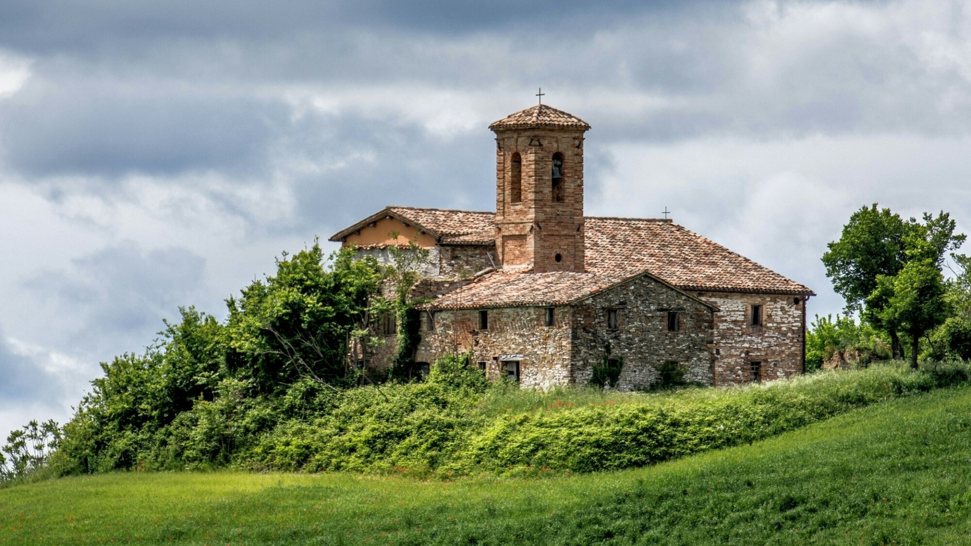 Stone building with bell tower on a hill HD Wallpaper