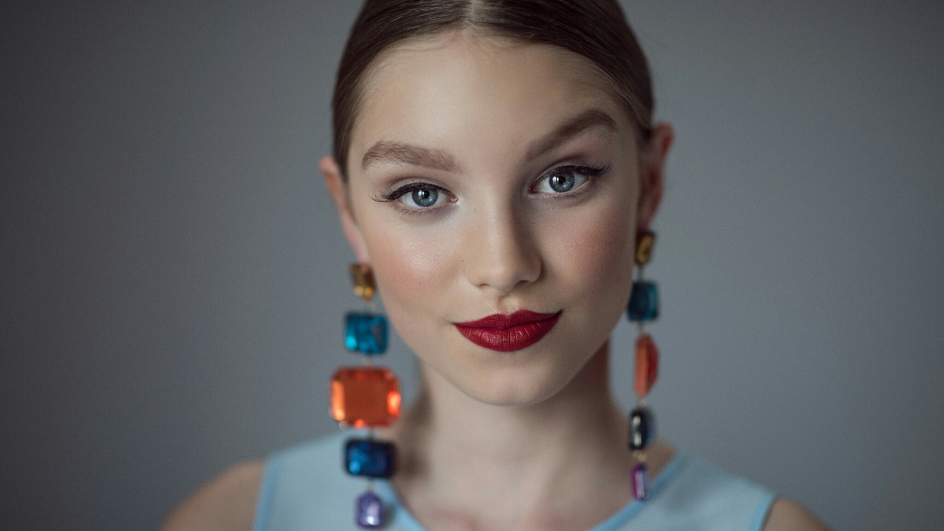 Young woman with colorful earrings HD Wallpaper