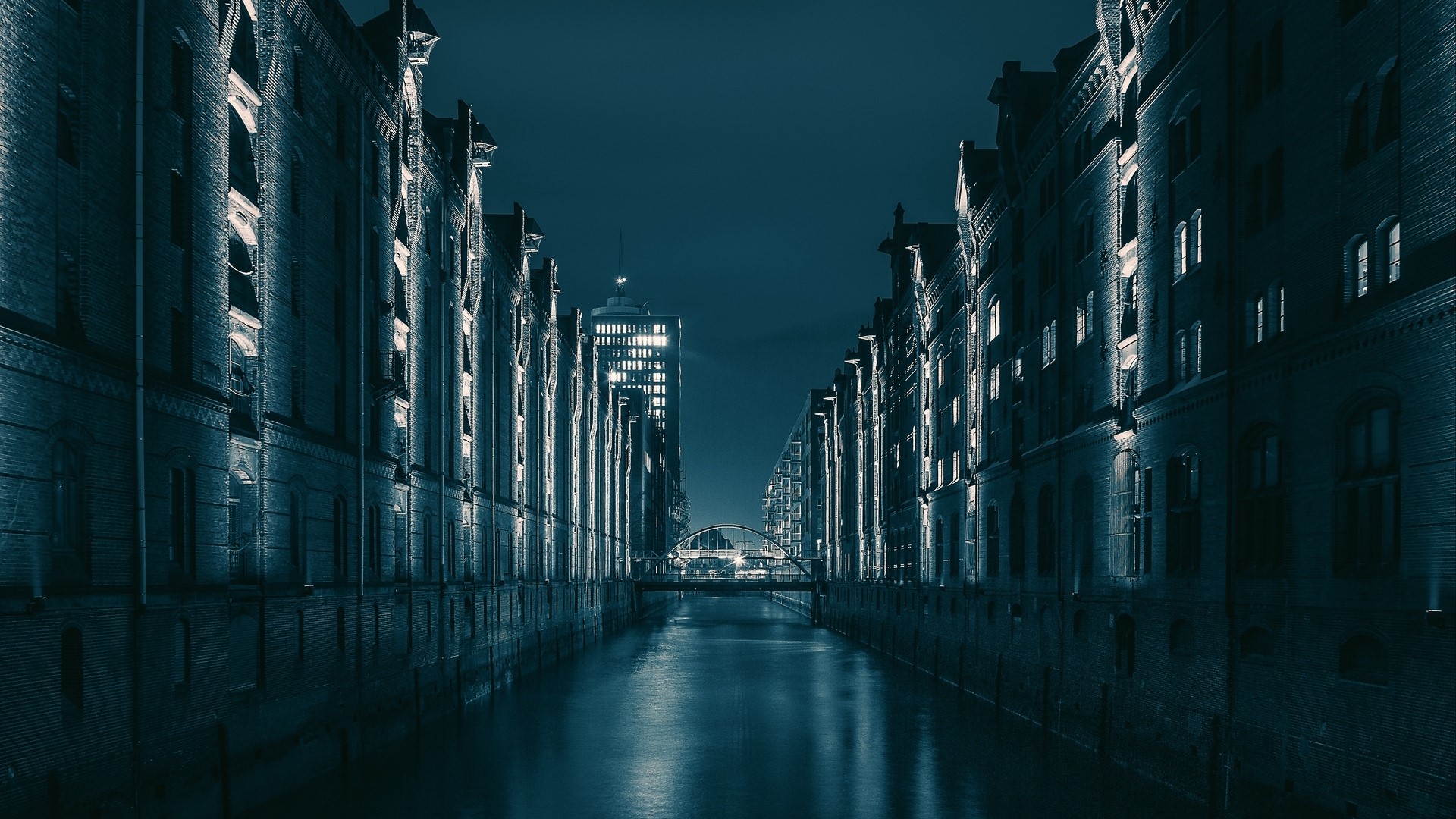 Night canal between brick warehouses and modern skyscraper HD Wallpaper