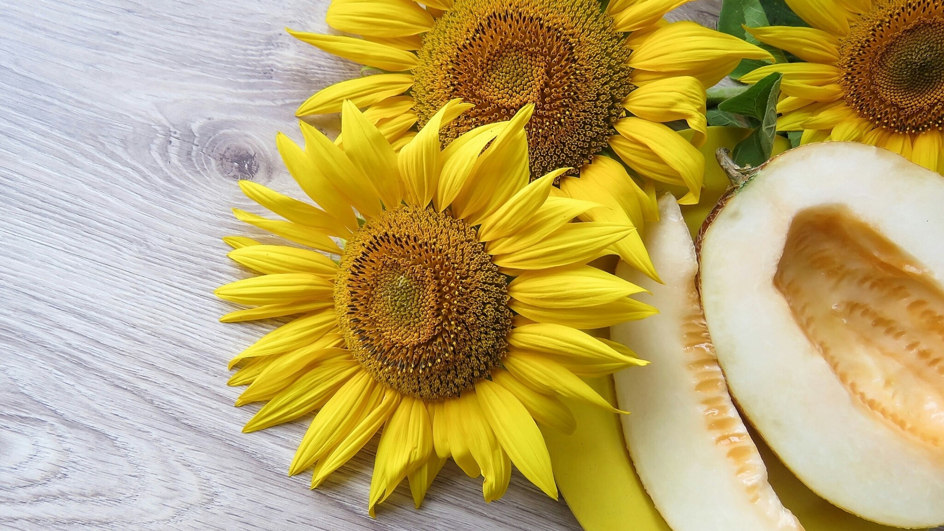 Sunflowers and melon on a wooden surface HD Wallpaper