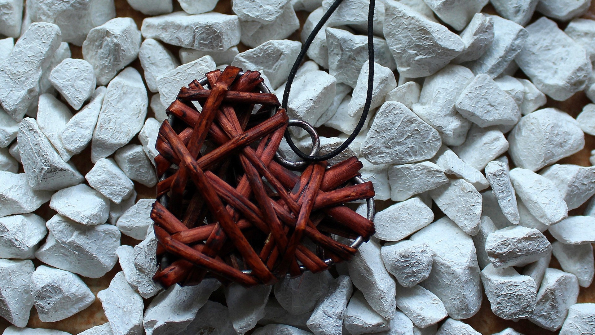 Heart pendant made of twigs on white stones HD Wallpaper