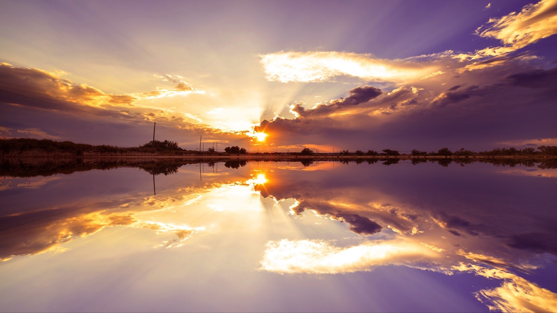 Sunset over a calm lake with dramatic clouds HD Wallpaper