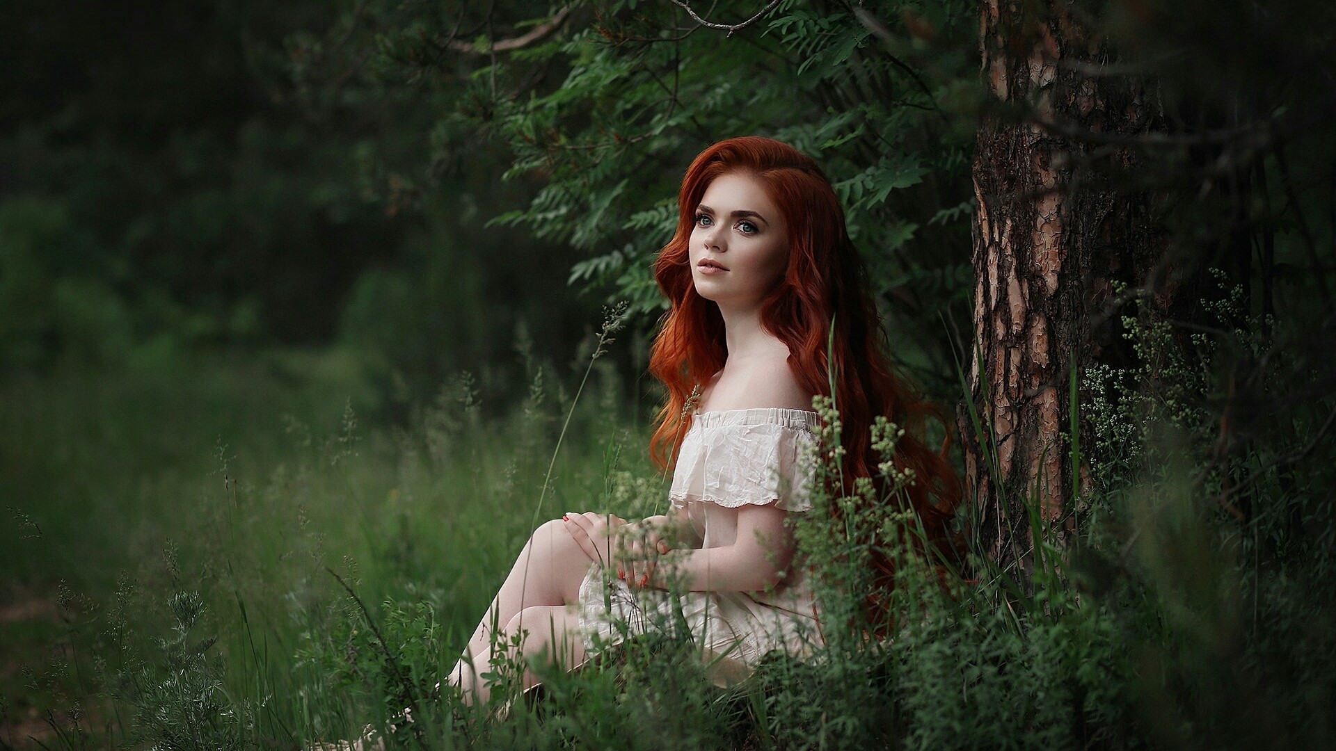 Young woman with red hair sitting in a forest HD Wallpaper