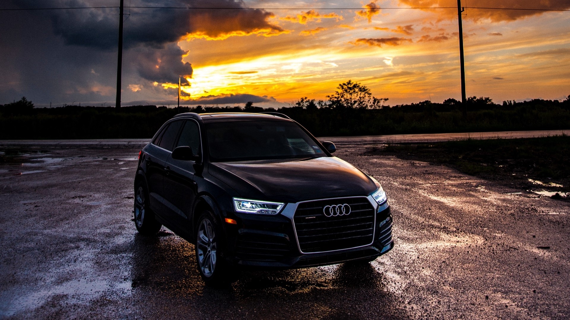 Black Audi parked on wet road at sunset HD Wallpaper