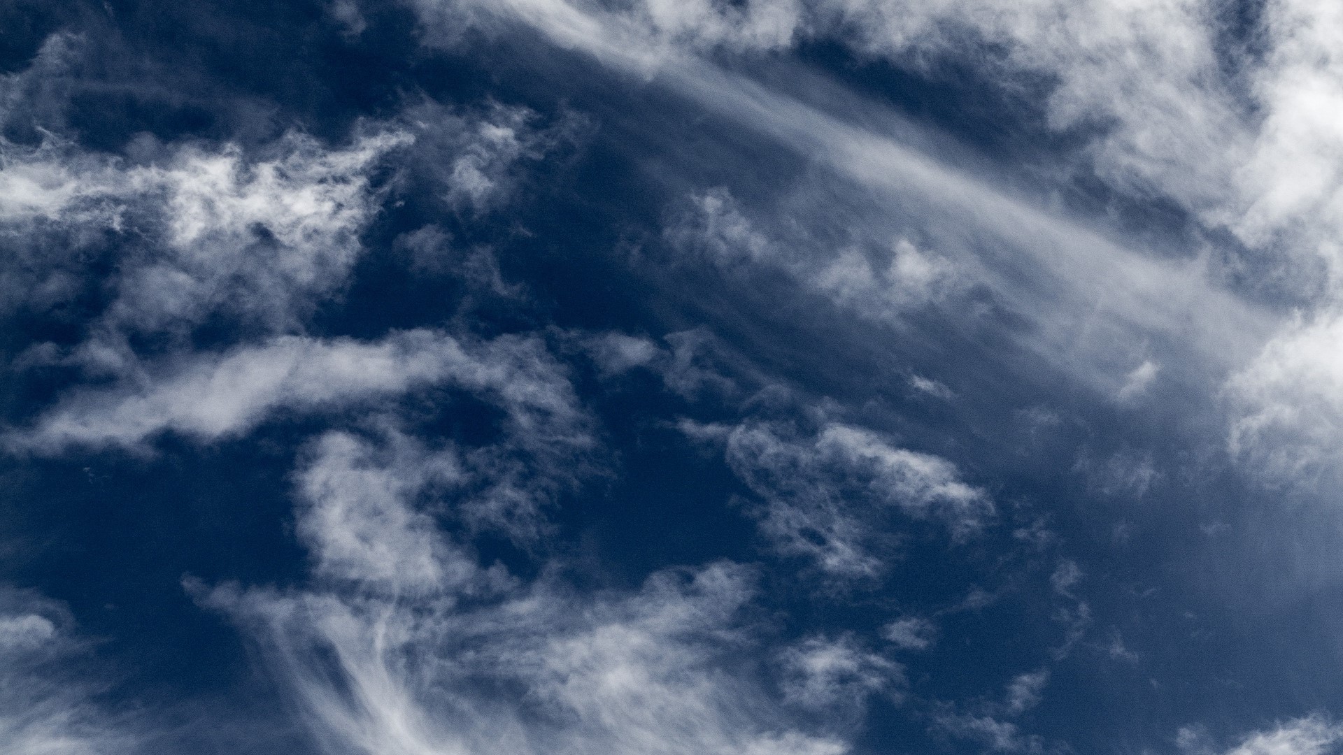Wispy clouds against a deep blue sky HD Wallpaper