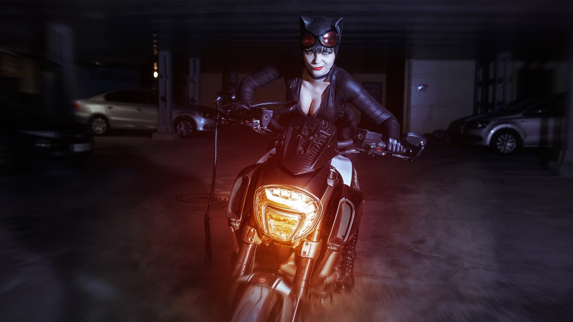 Catwoman on a motorcycle in a parking garage HD Wallpaper