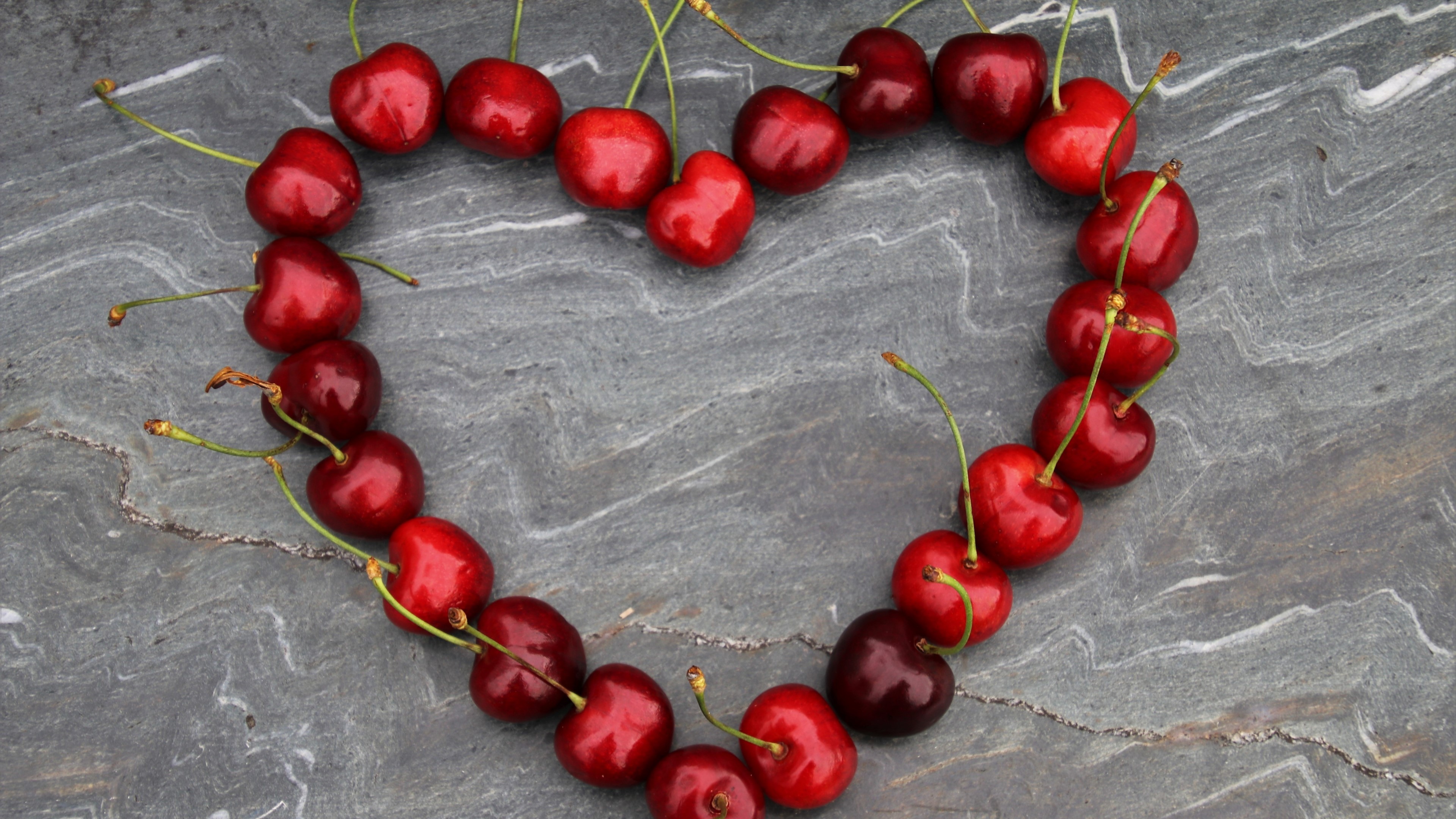 Cherries arranged in a heart shape HD Wallpaper