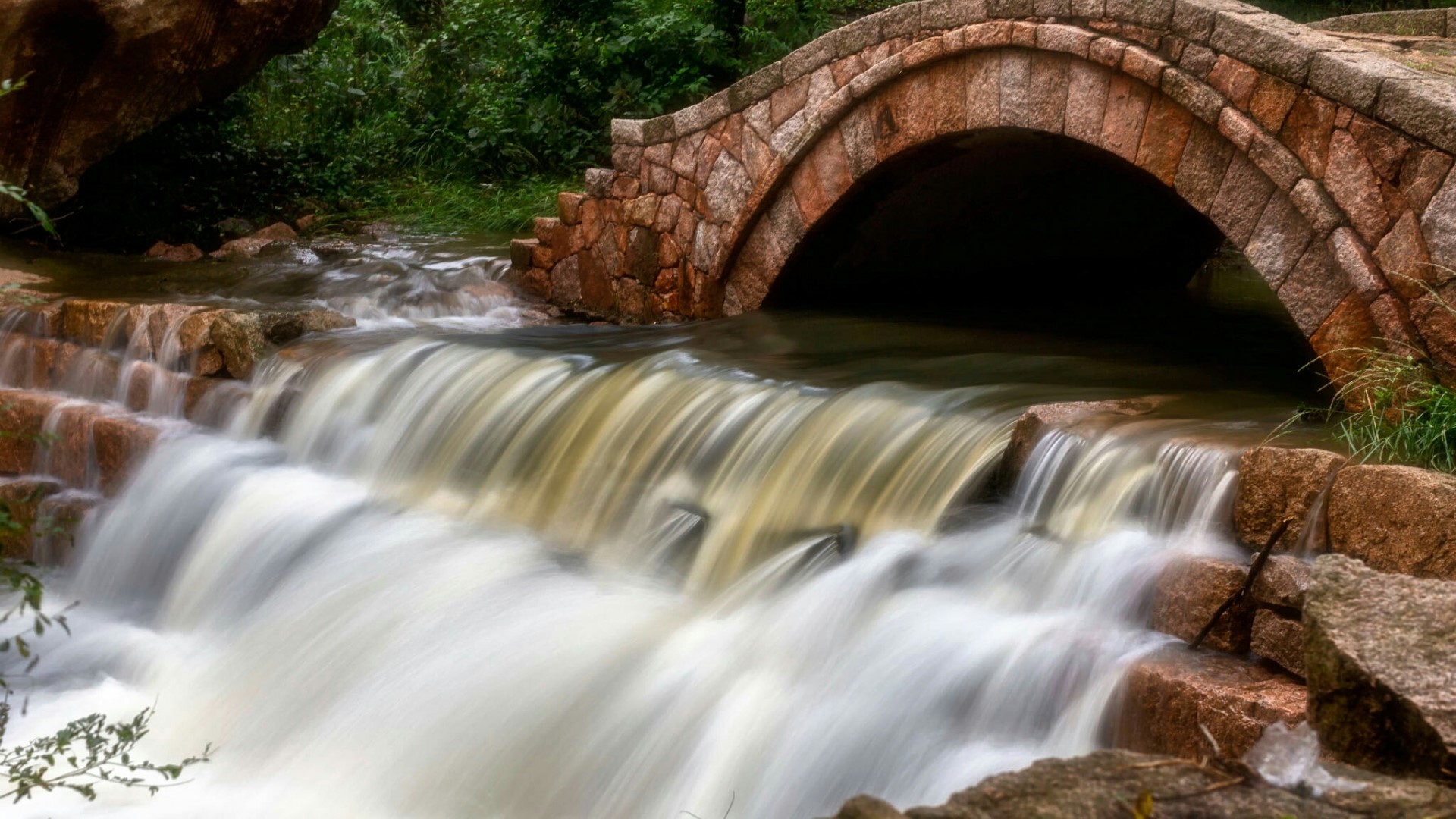 Stone bridge over a waterfall HD Wallpaper