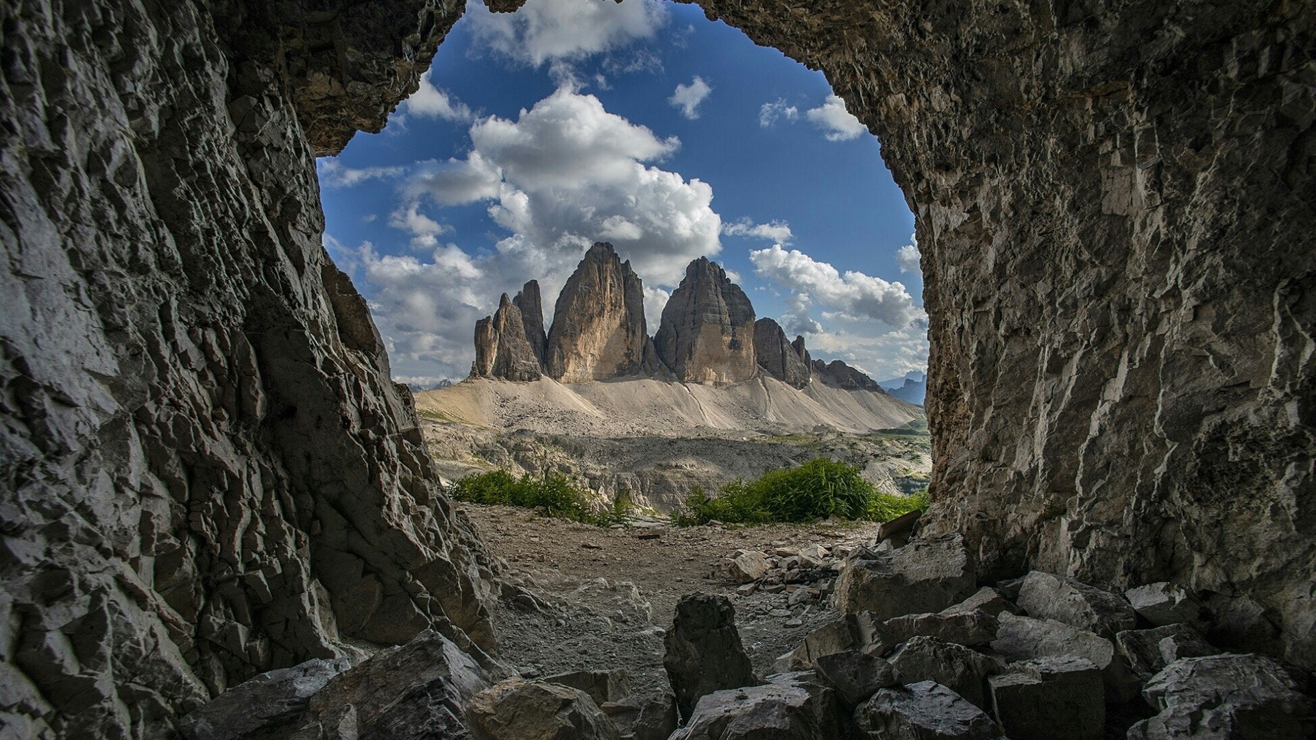 View of Tre Cime di Lavaredo mountains through a cave HD Wallpaper