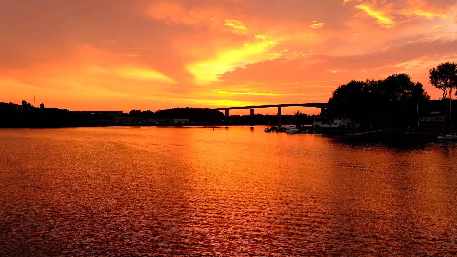 Sunset over river with bridge and trees HD Wallpaper