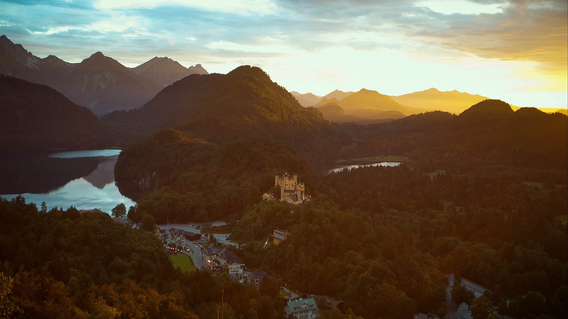 Castle on a hill at sunset with mountains and lake HD Wallpaper