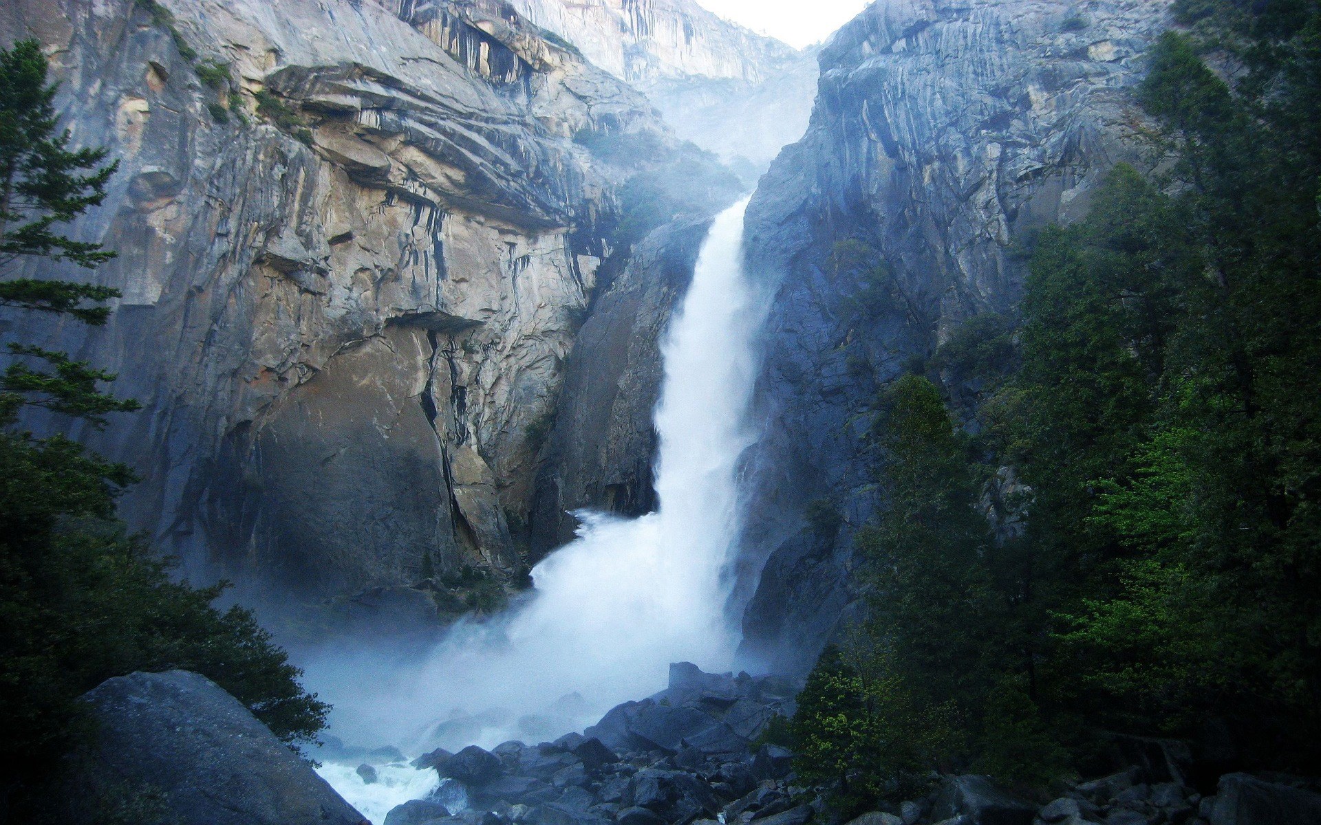 Waterfall cascading down a rocky cliff face HD Wallpaper