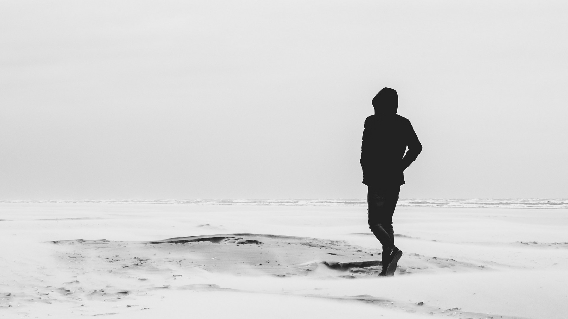 Silhouette of a person on a snowy beach HD Wallpaper