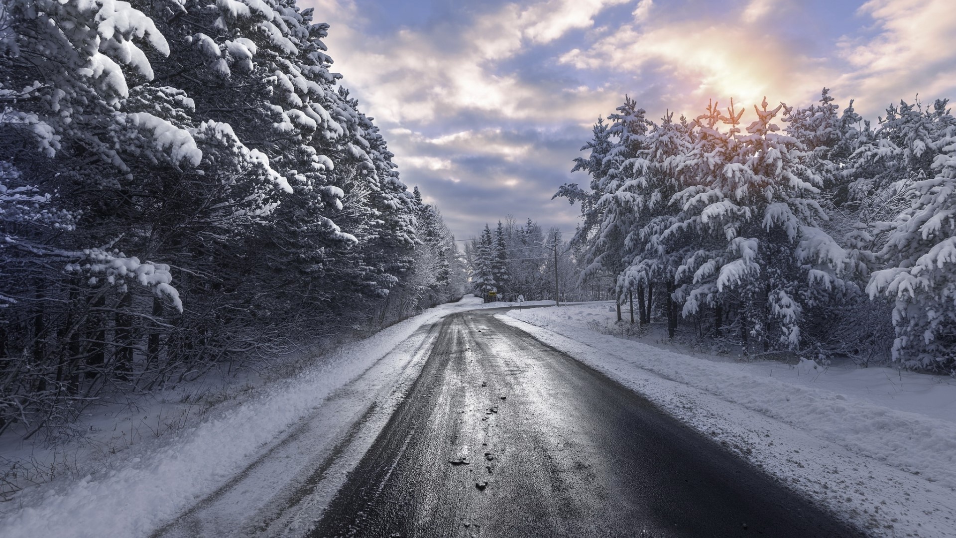 Snowy Forest Road with Sunlit Clouds HD Wallpaper