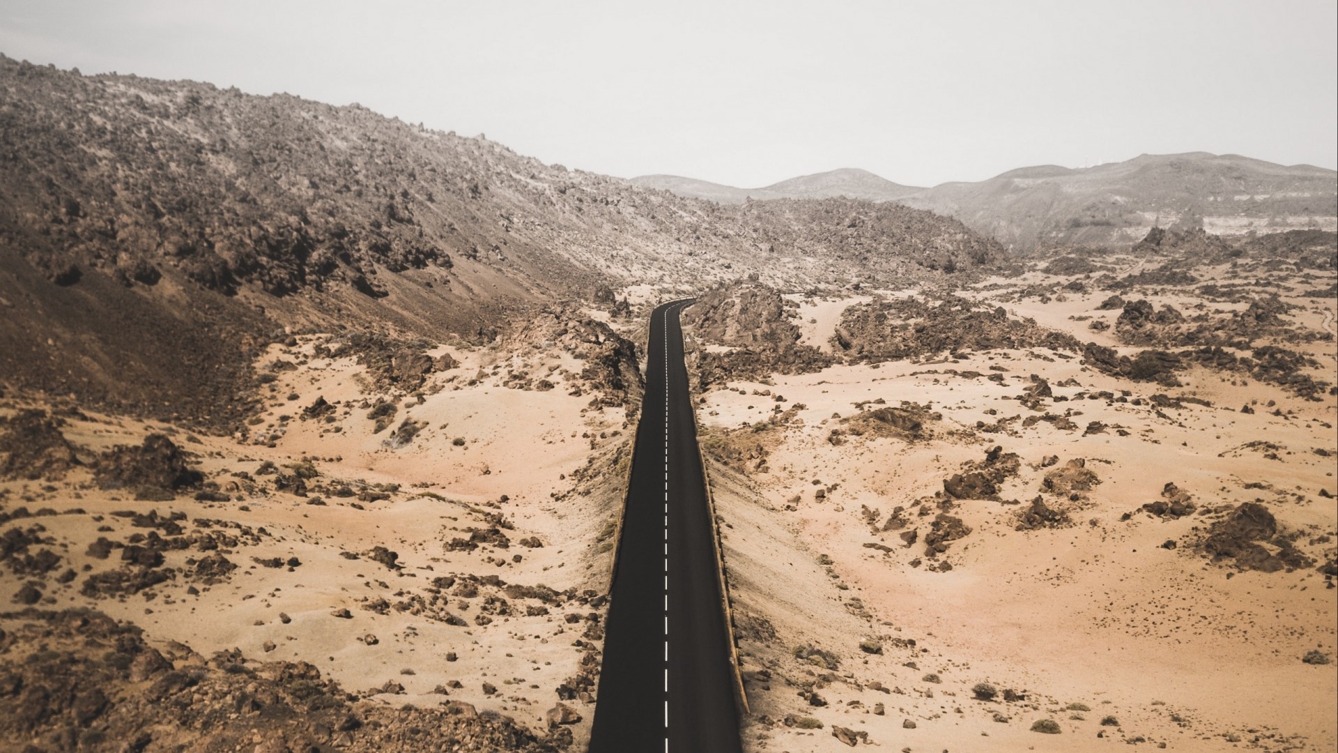 Desert road through rocky terrain HD Wallpaper