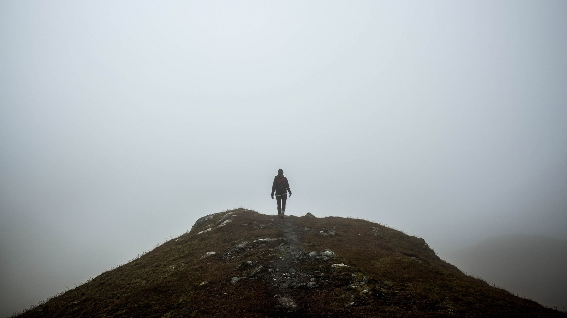 Person walking on a foggy mountain peak HD Wallpaper