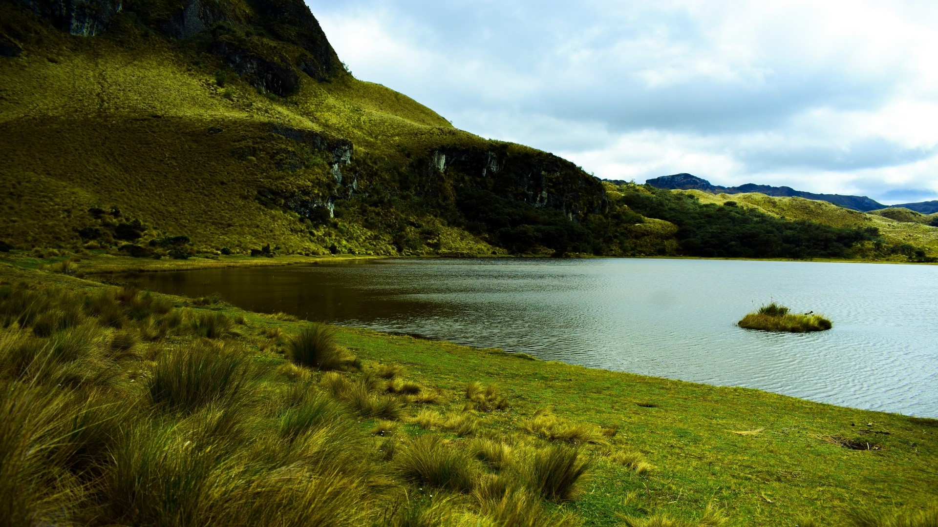 Lake and grassy hills under cloudy sky HD Wallpaper