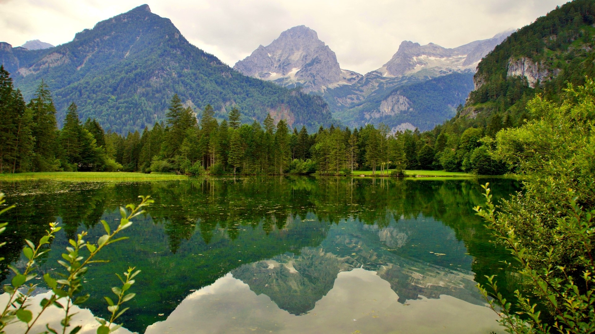 Mountains reflected in a lake with trees HD Wallpaper