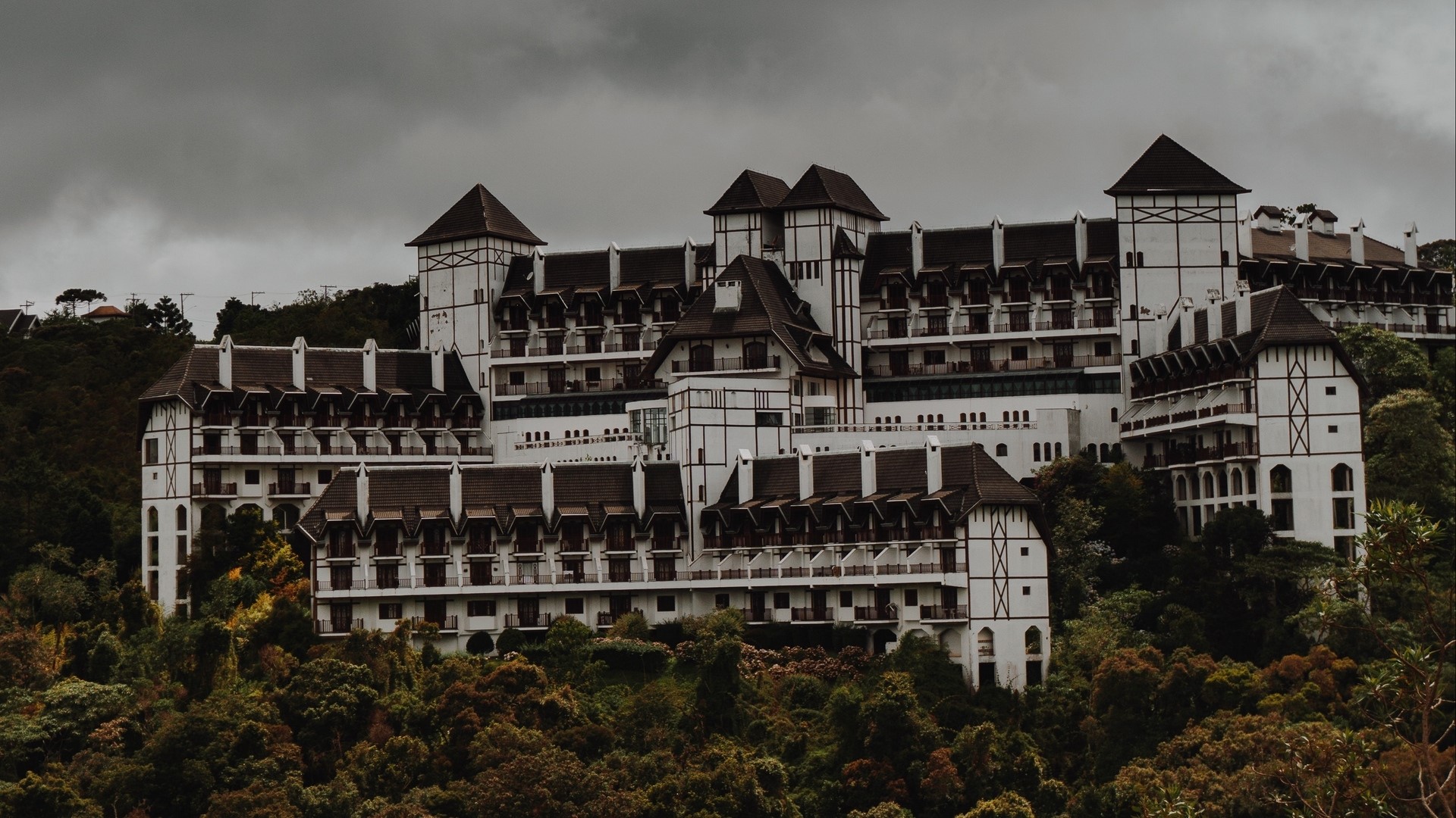 Large white hotel with dark roofs on a hill HD Wallpaper