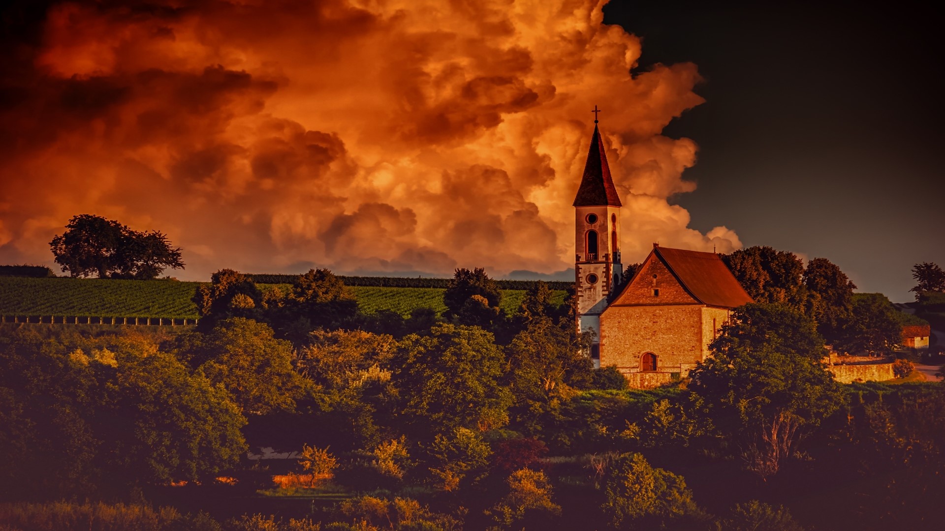 Church in Kaiserstuhl with dramatic clouds HD Wallpaper