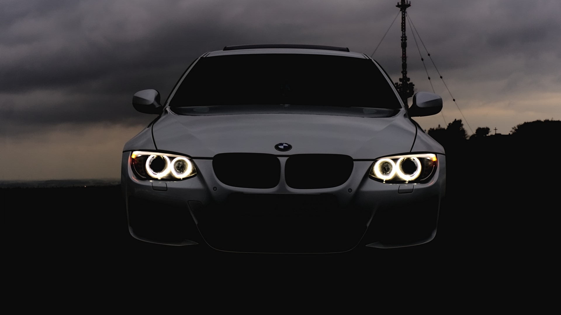 BMW car with glowing headlights at dusk HD Wallpaper