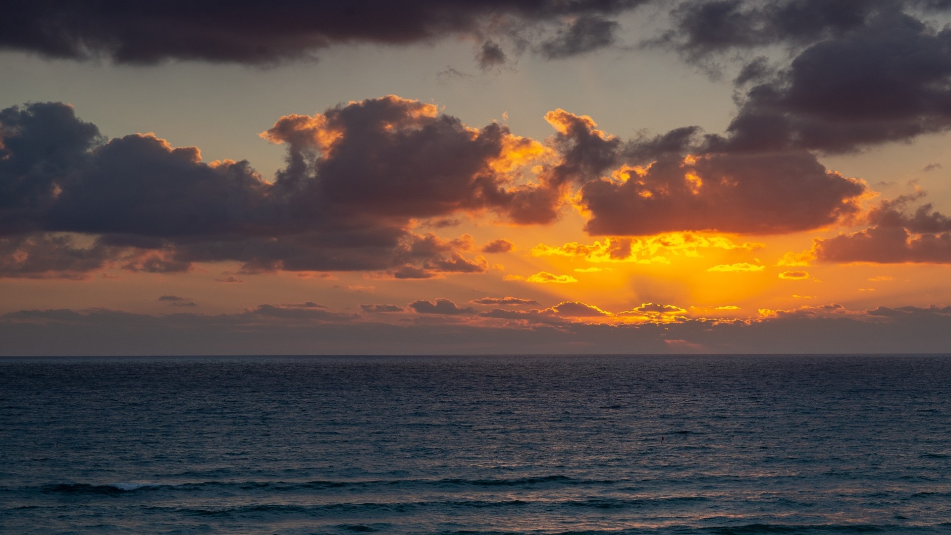 Sunset over the ocean with dramatic clouds HD Wallpaper
