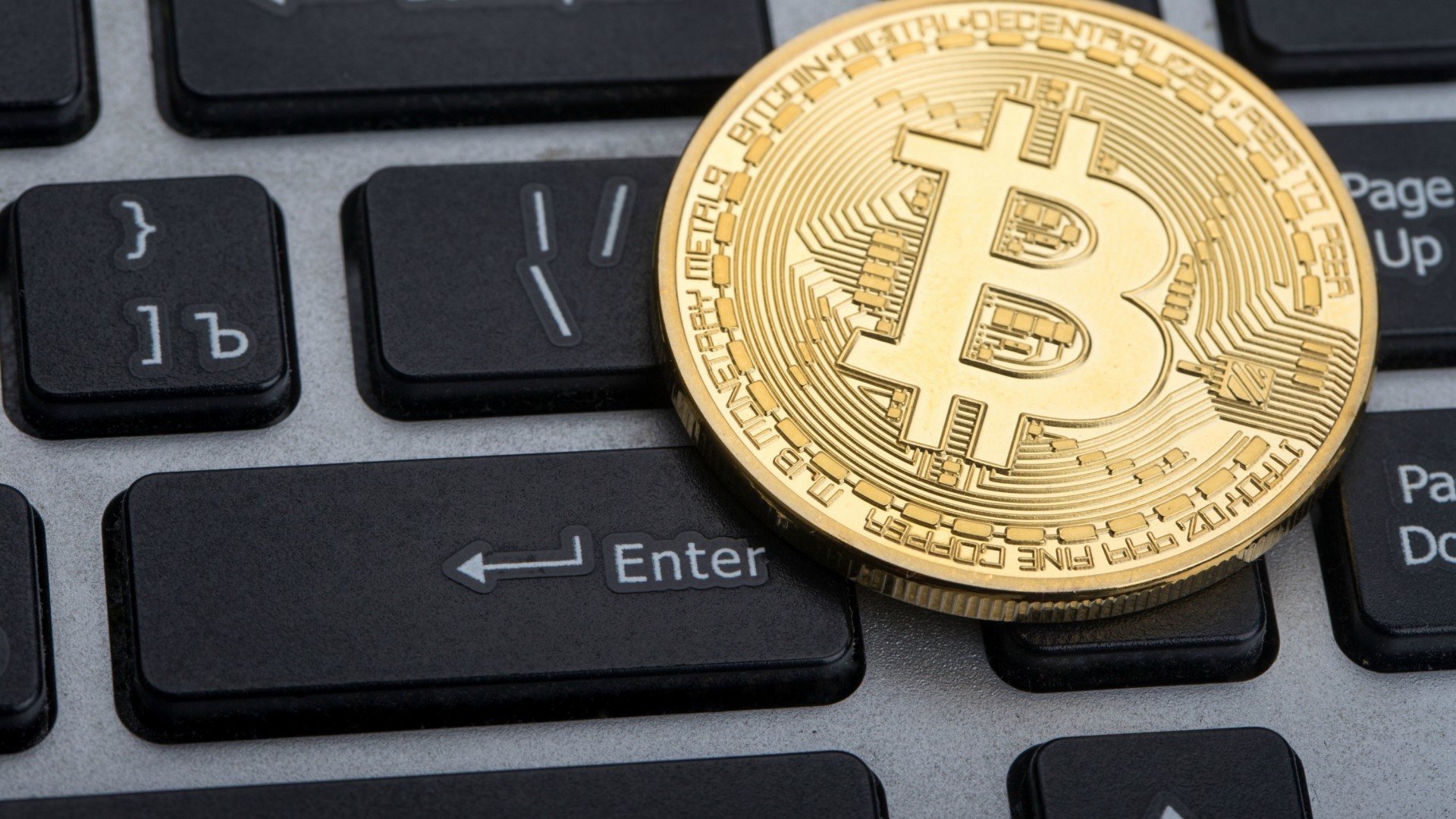 Bitcoin coin on a computer keyboard HD Wallpaper